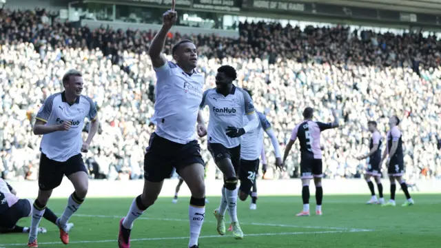 Carlton Morris celebrates with his finger in the air
