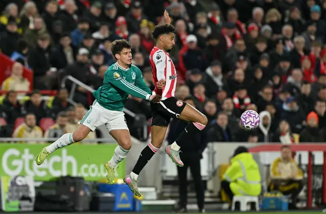 Milos Kerkez (L) and Kevin Schade (R) jump for the ball