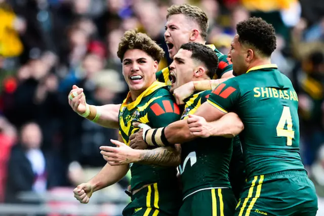 Reece Walsh of Australia breaks through to score a try and celebrates with teammates