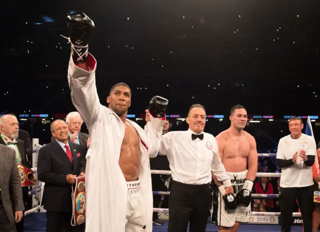 Anthony Joshua with his hand raised next to Joseph Parker