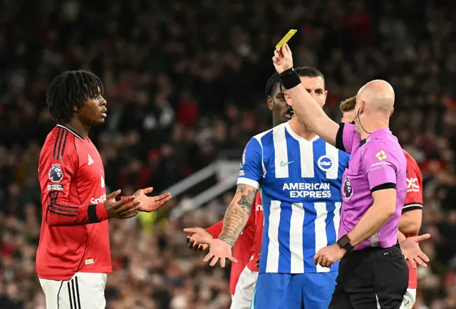 Referee Anthony Taylor (R) shows a yellow card to Manchester United's Danish defender #13 Patrick Dorgu