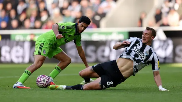 Raul Jimenez of Fulham is challenged by Dan Burn