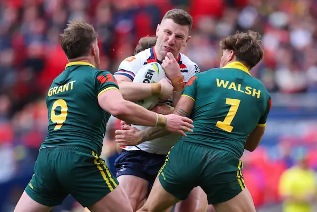 George Williams of England is tackled by Reece Walsh of Australia and Harry Grant of Australia
