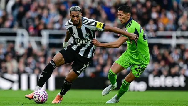 Joelinton of Newcastle United turns away from Saša Lukić of Fulham FC