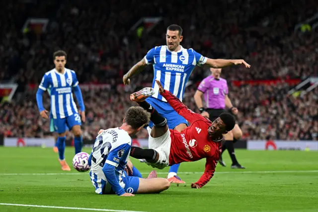 Amad Diallo of Manchester United is tackled by Maxim De Cuyper and Lewis Dunk of Brighton