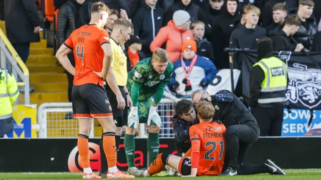 Dundee United's Luca Stephenson receives treatment