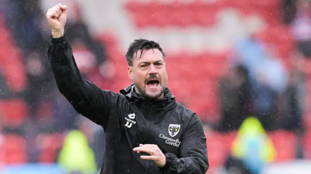 A celebrating AFC Wimbledon boss Johnnie Jackson