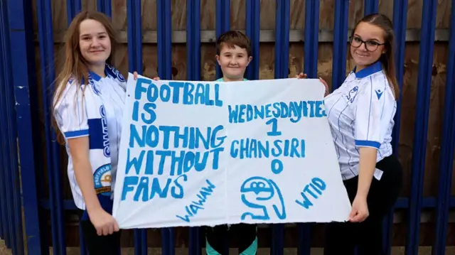 Young Sheffield Wednesday fans hold a banner saying, "Football is nothing without fans: Wednesdayites 1-0 Chansiri"