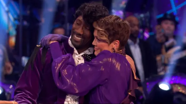 A man and woman hugging in purple