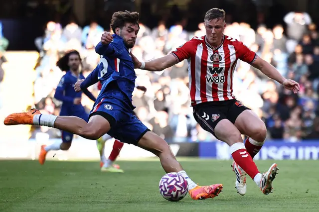 Marc Guiu (L) vies with Dan Ballard (R)