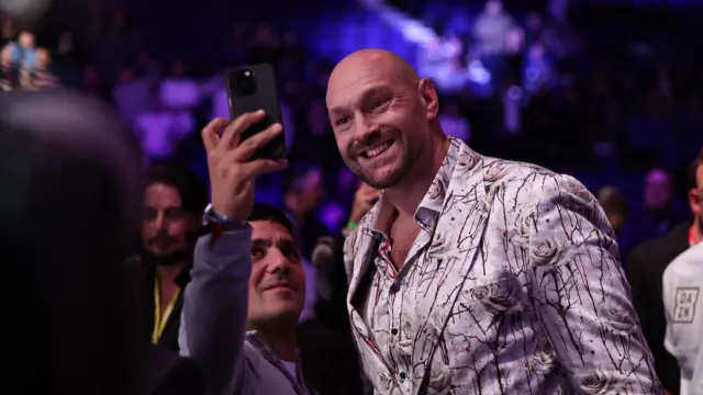 Tyson Fury poses for a picture with a fan