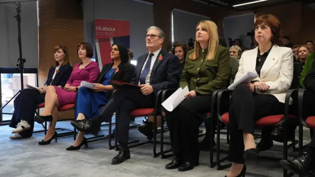 Labour Party members wait sitting down for announcement. Lucy Powell sits on the far right, Starmer in the middle next to Shabana Mahmood, Bridget Phillipson to her left