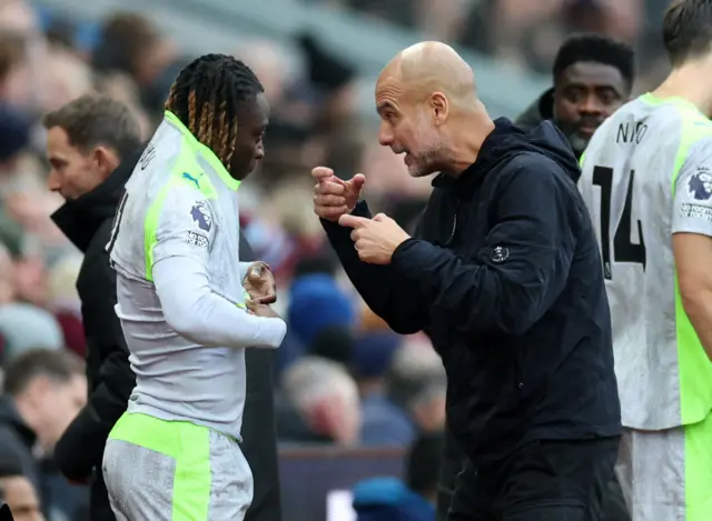 Jeremy Doku speaks to Pep Guardiola