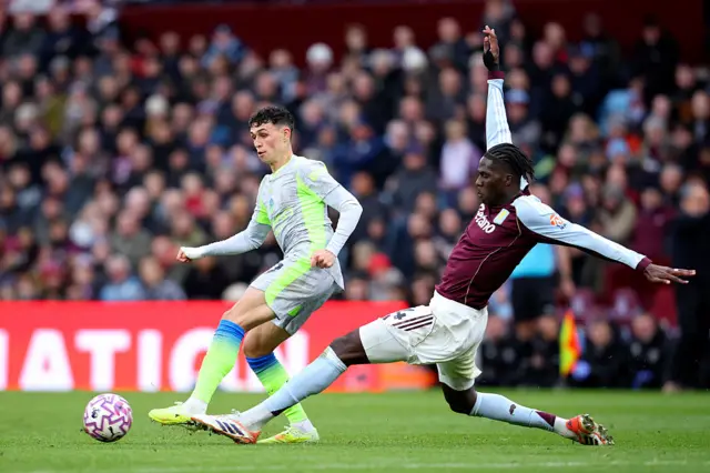 Phil Foden of Manchester City and Amadou Onana of Aston Villa challenge during the Premier League match between Aston Villa and Manchester City at Villa Park on October 26, 2025 in Birmingham, England.