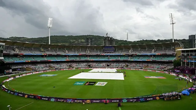 Grey clouds loom over the DY Patil Stadium in Navi Mumbai on October 26, 2025, as rain delays the start