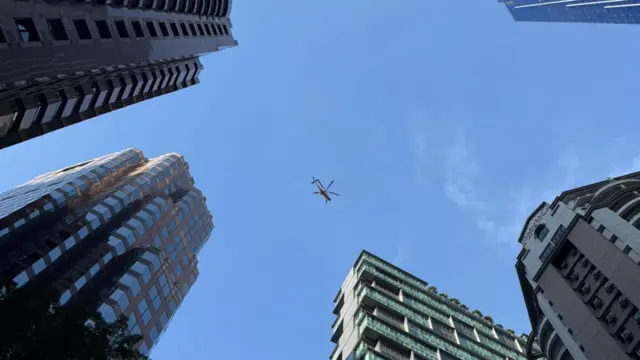 A helicopter patrolling skies above buildings