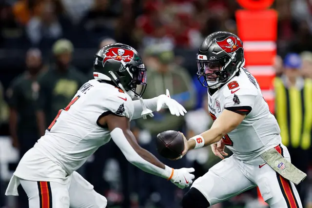 Baker Mayfield hands the ball off to Rachaad White