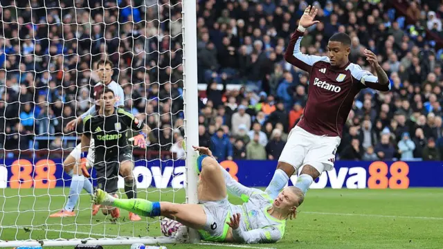 Erling Haaland collides with a post as he squeezes the ball over the line at Villa Park