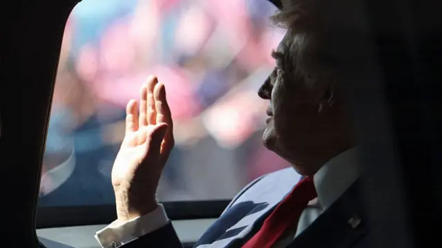Donald Trump waves from his car