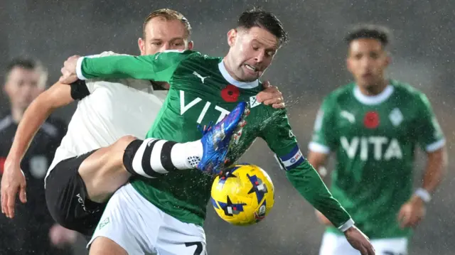 Ryan Croasdale and Oliver Norwood battle for the ball