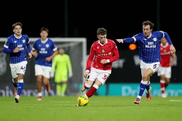 Nathan Broadhead of Wrexham is challenged by Ryan Wintle of Cardiff City