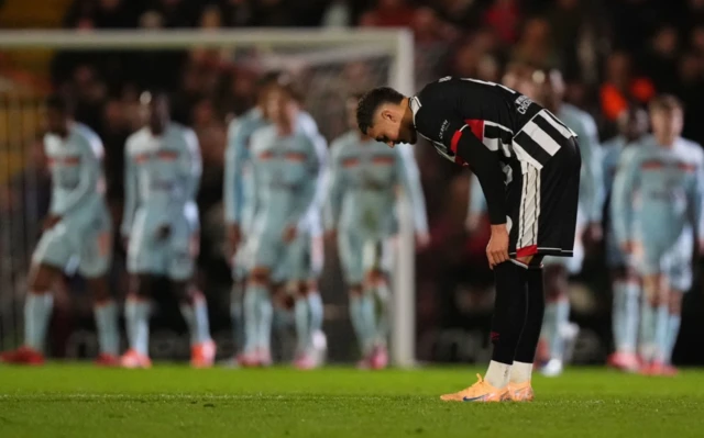 Grimsby Town's Jaze Kabia adjusts his socks after Brentford's Keane Lewis-Potter scored