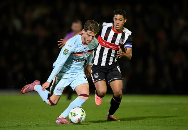 Mathias Jensen of Brentford runs with the ball whilst under pressure from Evan Khouri