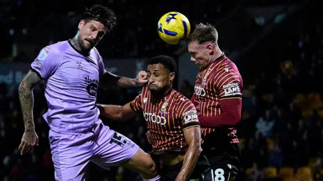 Sonny Bradley of Lincoln City vies for possession with Ibou Touray and Ciaran Kelly of Bradford City