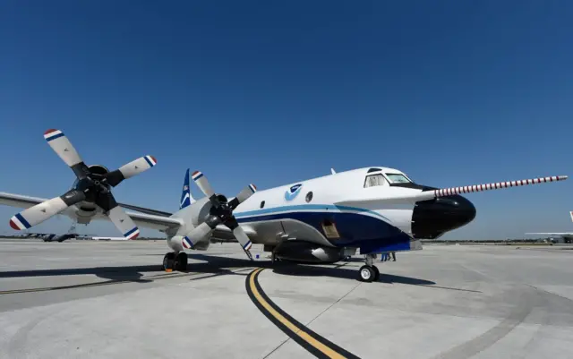 One of NOAA’s WP-3D Orion Hurricane Hunter aircraft, it has propeller engine and a long, thin sensor protruding on the front by a few metres.
