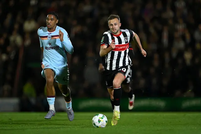 Charles Vernam of Grimsby Town runs with the ball whilst under pressure from Benjamin Arthur