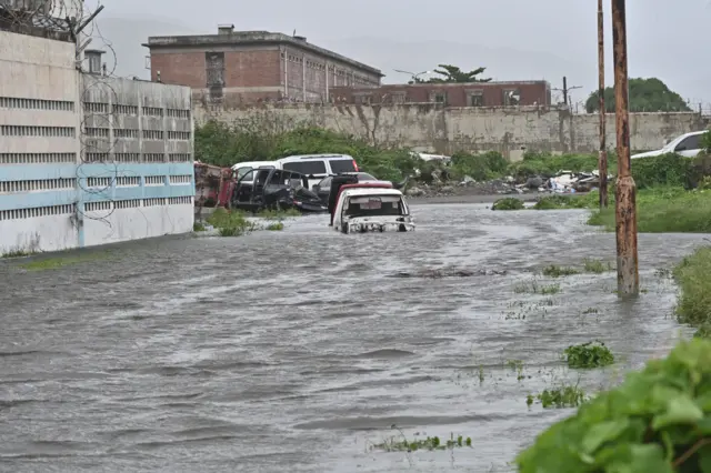 road flooded with water going halfway up a car