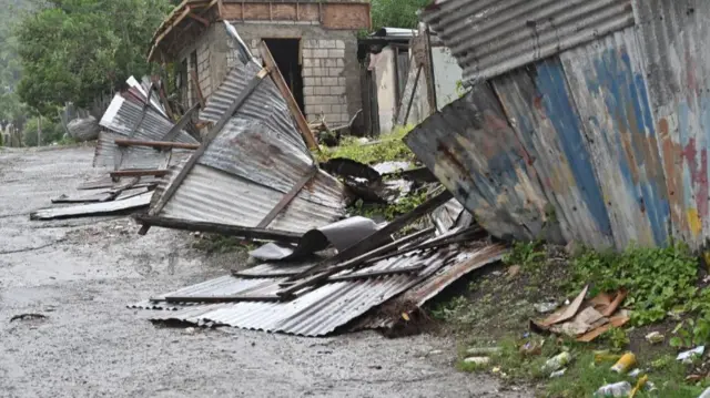 A damaged home and fence seen in Kingston