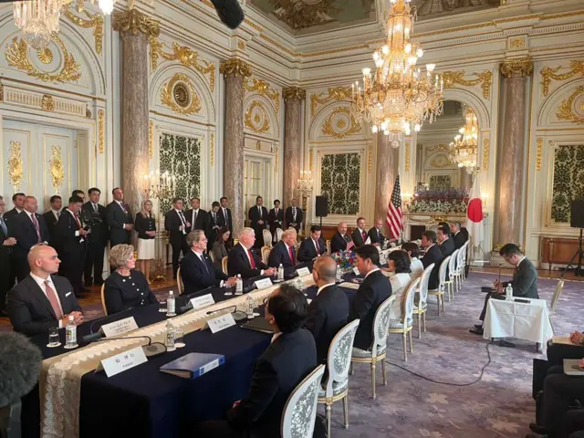 Donald Trump and US officials meeting with Sanae Takaichi and Japanese officials all seated on a long table inside an ornate room