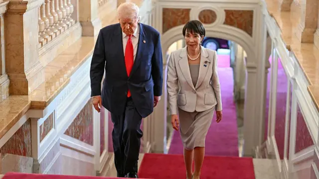Trump và Takaichi bước lên cầu thang được trải thảm đỏ