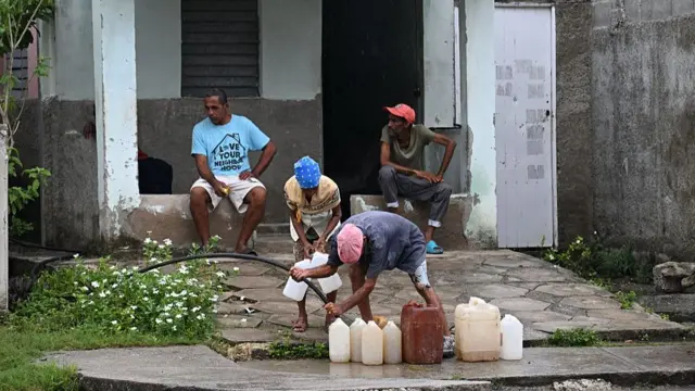 Men fill containers with drinking water