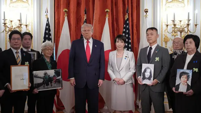 Trump Takaichi posing in a row with people carrying framed photographs