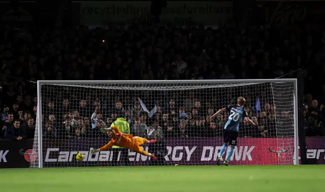 Benjamin Lecomte of Fulham saves the first penalty from Ewan Henderson