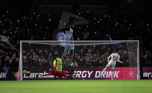 Will Norris of Wycombe Wanderers fails to save the first penalty from Sasa Lukic