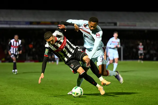 Jaze Kabia of Grimsby Town is challenged by Ethan Pinnock