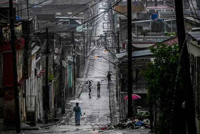 A woman walks in a street before Hurricane Melissa hits the city of Santiago de Cuba, Cuba