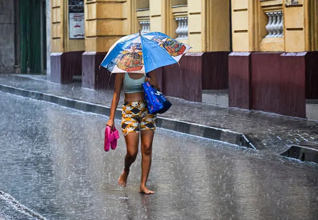 A woman walks in a street before Hurricane Melissa hits the city of Santiago de Cuba, Cuba, on Tuesday