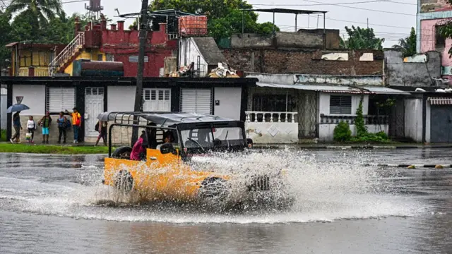 Residents drive a car through flooded areas before Hurricane Melissa hits the city of Santiago de Cuba, Cuba on 28 October 2025