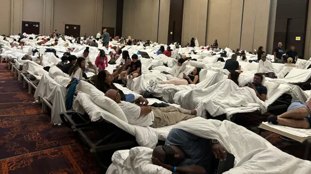 People sleep at a hotel shelter