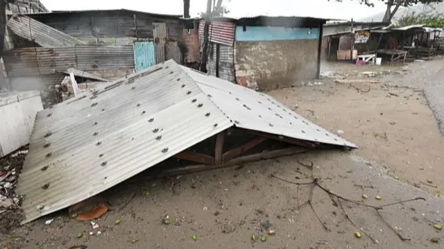 A metal roof lies on the floor