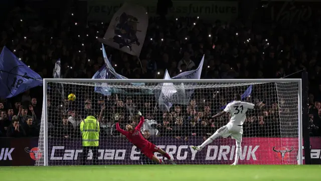 Will Norris of Wycombe Wanderers fails to save the seventh and winning penalty from Issa Diop of Fulham