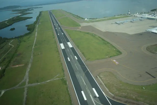 Aerial photo of Kingston airport showing no damage. In the background is greenery and a waterbody.
