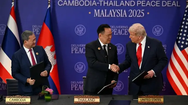 Trump shaking hands with Thai prime minister Anutin as Cambodian leader Hun Manet looks on from the side
