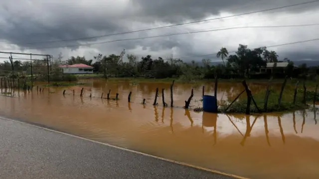 Brown floodwater has submerged a road