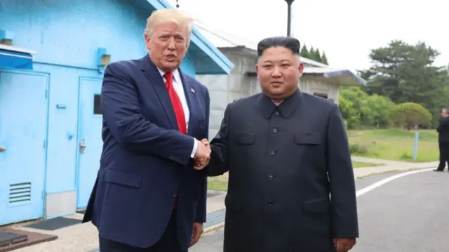 Donald Trump shaking hands with Kim Jong Un at the DMZ