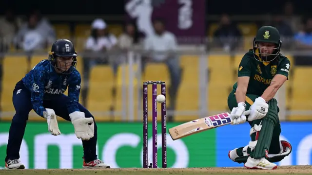Wicket keeper Amy Jones of England looks on as Tazmin Brits of South Africa plays a reverse sweep shot